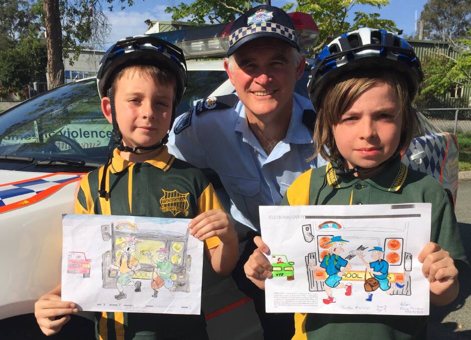 WINNERS ARE GRINNERS: Jimboomba Police Senior Sergeant Peter Waugh congratulates local students Edward Fitzgerald and Jordan Narcisi on being among the winners of the road safety colouring contest.