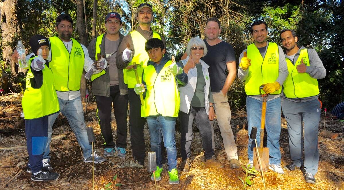 PLANTING: Ahmadiyya tree planting volunteers with Planet Ark organisers. Photo: Supplied