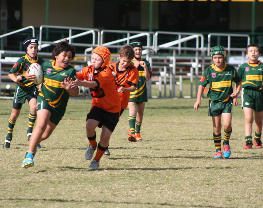 Strong running: Paamu Wall from the under 9s runs the ball supported by his Thunder teammates.
