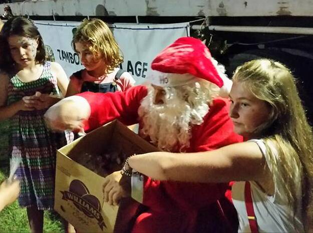 LOLLIES: Santa hands out some treats to children at Tamborine Village.