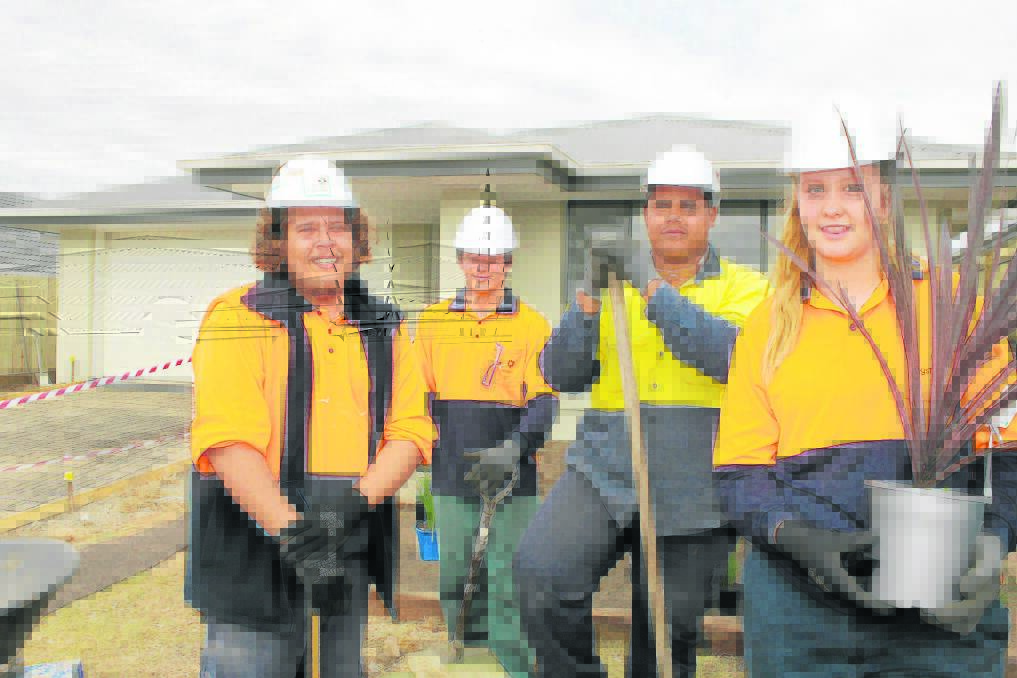 Logan young people Luke Craig, 22, Brendan Clevens, 18, Jarrod Pickering, 18, and Madeline Peace, 14, work in the front garden of the home they constructed 
at Yarrabilba.