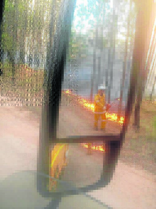 A firefighter monitors the blaze on Saturday. Source: Chambers Flat Rural Fire Brigade Facebook page.