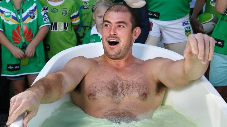 Sunday Times: Canberra Raiders captain Terry Campese reacts as he lowers himself in a bath of Raiders Lime during the members day at Canberra Stadium. 23 March 2013. Canberra Times Photograph by Jeffrey Chan