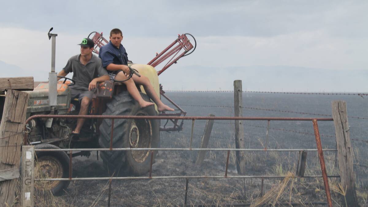 Farmers Nathan Adams and Carl Christoffel were quick to respond to a grass fire started by sparks from a rocket at the Queensland Rocketry Society's community launch day at Cedar Grove. 
