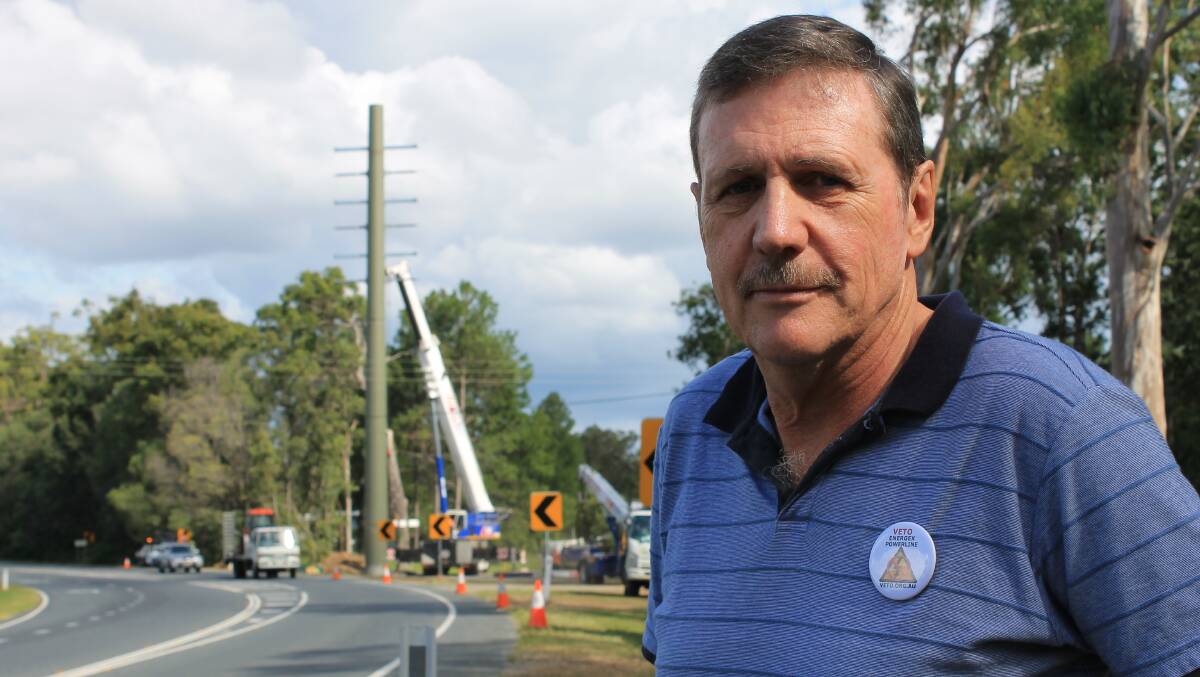VETO president Paul Casbolt looks on as workers erect a 25 metre concrete power pole on Waterford-Tamborine Road.