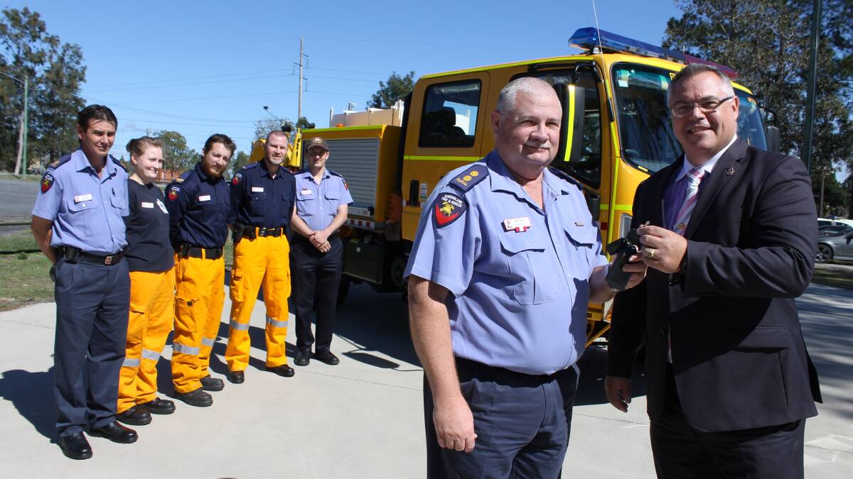Chambers Flat Rural Fire Brigade First Officer David Heck accepts the keys to a new state-of-the-art fire truck from Logan MP Michael Pucci, as firefighters Colin Whyte, Chelsea Suther, Daniel Boyes, Stephen Rasmussen and Lachlan Weatherston watch on.