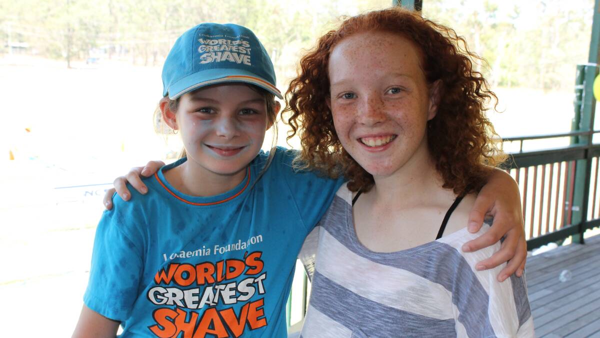 Brieanna Hastie, 10, of Logan Village and Tia Gee, 13, of Cedar Vale catch up at the Logan Village Falcons’ charity day.
