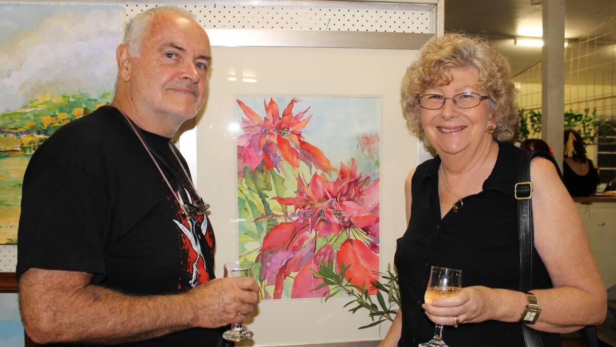 Mike and Margaret Eddy admire one of Margaret's paintings at the Quota Art Show.