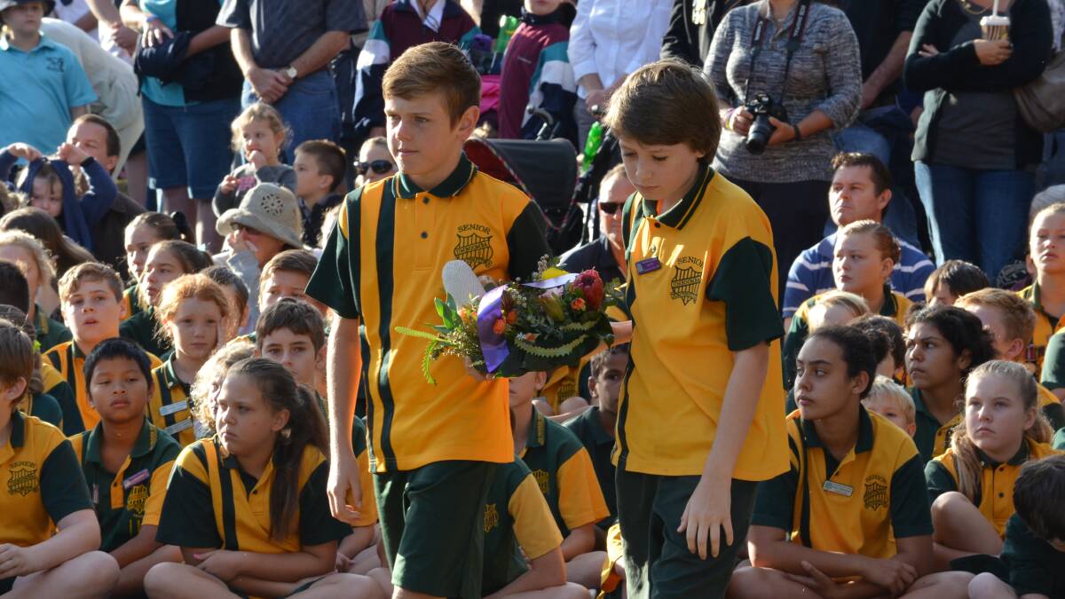 Jimboomba State School students Noah Fryer and Tom Casey come forward from the crowd to lay a wreath.