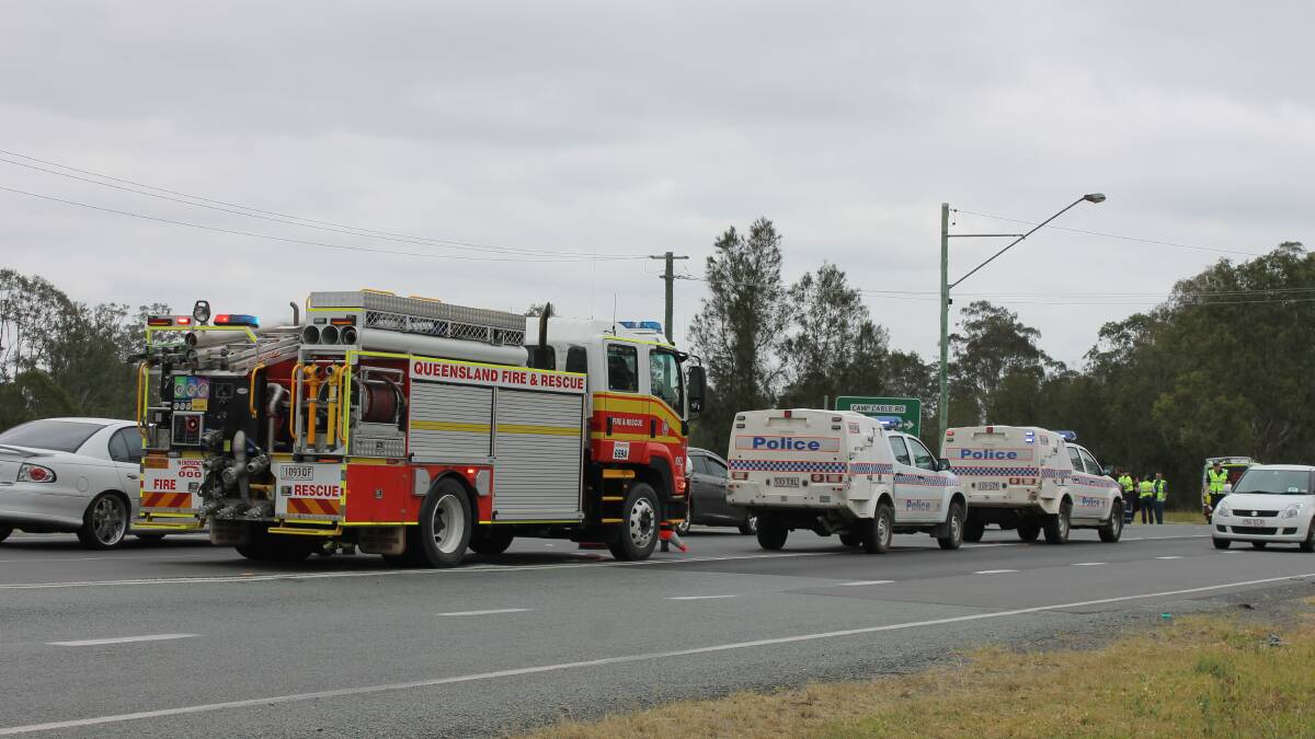 Emergency services at the scene of a crash on the Mt Lindesay Highway at the intersection with Camp Cable Road.