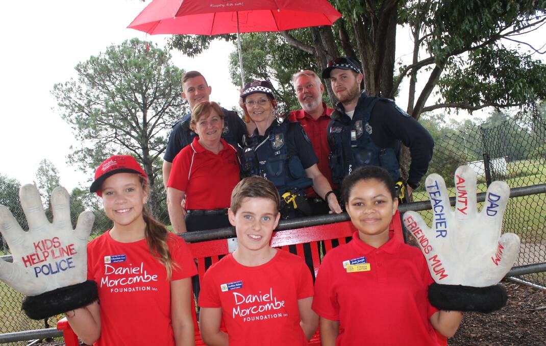 Park Ridge State School student captains Charlotte Lee and Lachlan Nelson and vice captain Jada Joseph gather around the school's Day for Daniel bench with Bruce and Denise Morcombe and Browns Plains Police constables Michael McEwan, Leanne Cole and Barry Hartshorn.