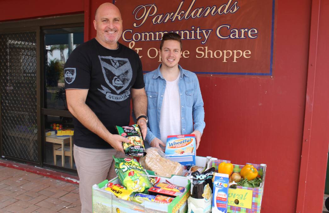 Parklands Christian Centre pastors Mike Warman and Blake Reynolds with one of the $30 food packages available for people to buy from October 15.