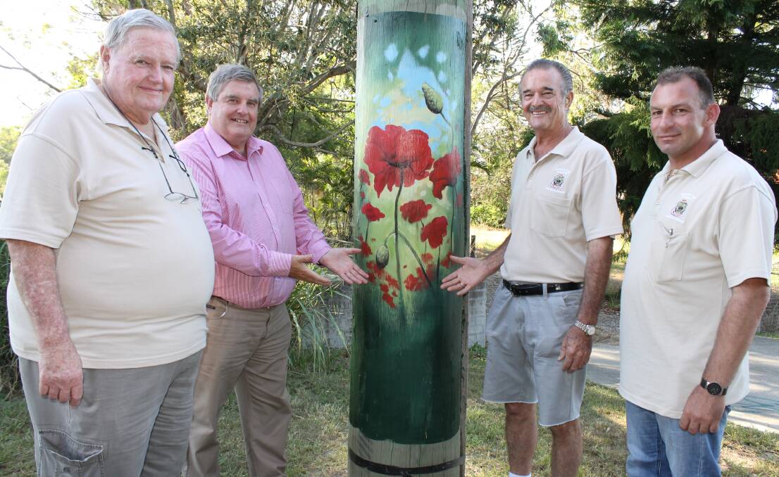 Division 7 Councillor Laurie Smith (second left) and Greenbank RSL sub-branch Anzac Day committee members Noel Brown, Tom McGee OAM and Glen Barton with one of the power poles on Anzac Avenue painted with poppies.