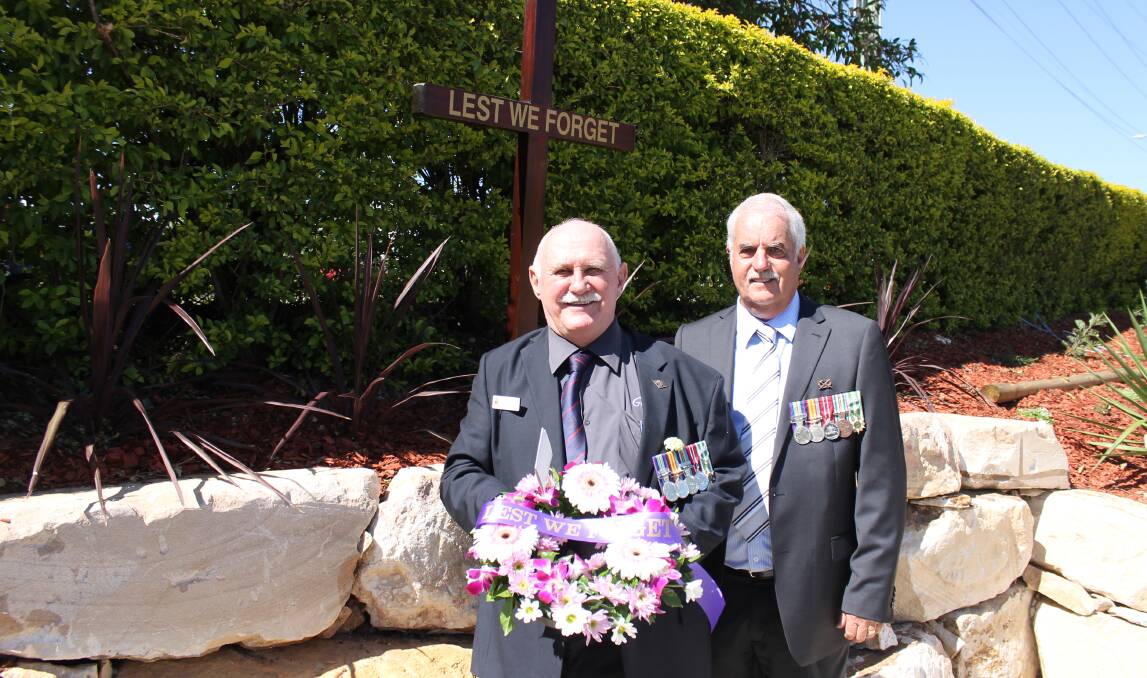 Greenbank RSL sub-branch members Terry Hippisley and Howard Buckley with the wreath laid at the Anzac Day service on behalf of the sub-branch.