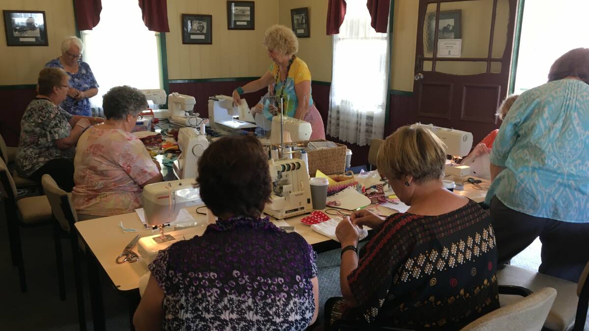 Members of the Do-Dropp-Inn community craft cottage in action