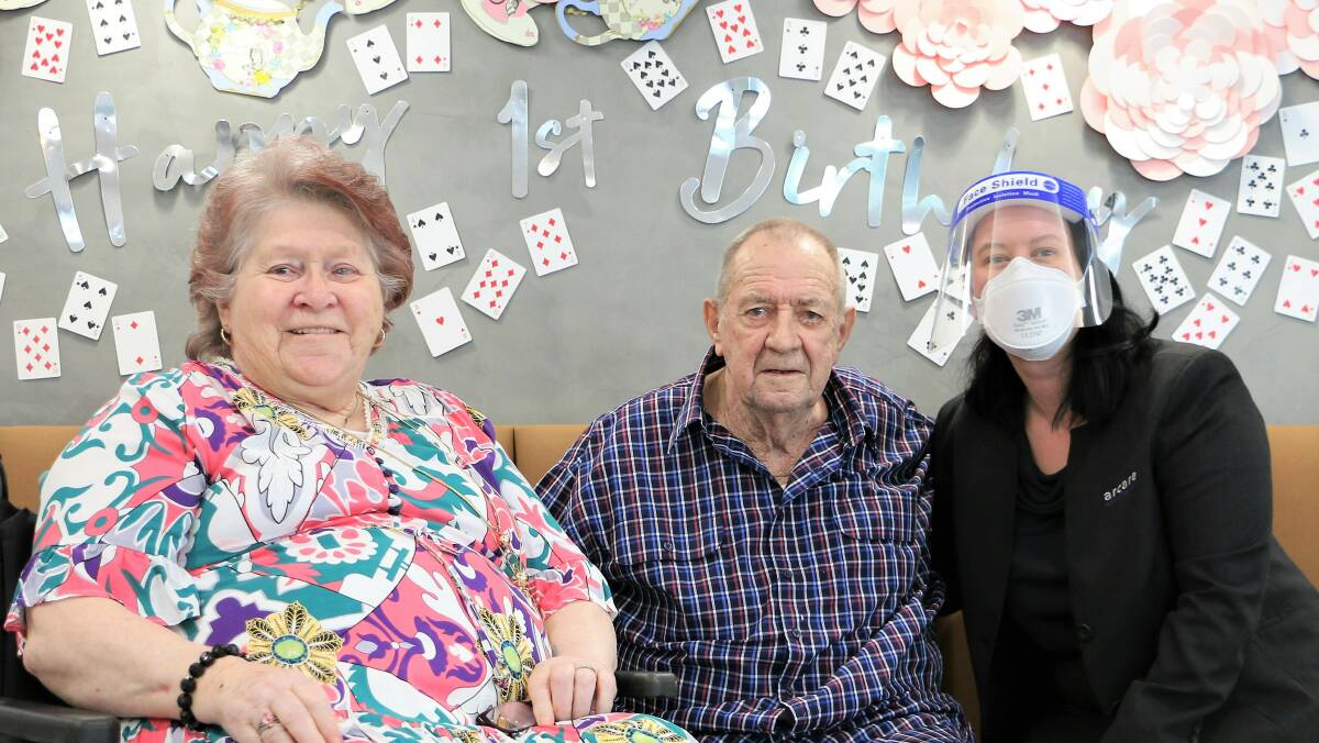 ONE YEAR ON: Arcare Logan Reserve's very first residents Shirley and Neil Parsons celebrate with Resident Manager Hayley Palmer. Picture: Arcare Logan Reserve.
