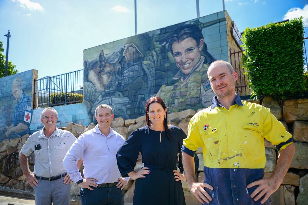 SALUTE: Greenbank RSL sub branch board member Tom McGee OAM, Cr Tim Frazer, Cr Natalie Willcocks and artist Laing Rahner unveil the new mural at Greenbank Services Club. Picture: Logan City Council.