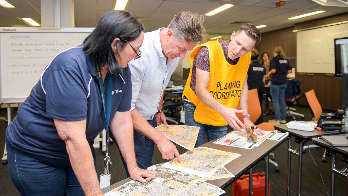 PLANNING: Mayor Darren Power and Infrastructure Chair Cr Teresa Lane check
flood modelling at Logan City Councils Disaster Coordination Centre. Picture: Logan City Council.