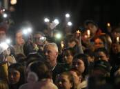 Mourners use phone lights and candles in Ballarat after the murders of three women. Picture by Lachlan Bence