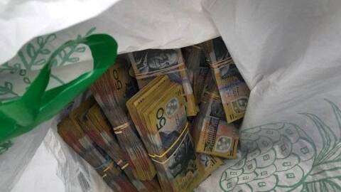 CASH: Police seized a large amount of cash from a Jimboomba man in Southport. Photo: Queensland Police Service