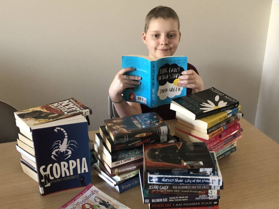 AVID READER: Lucy Newman is collecting books to fill a library for sick children at Lady Cilento Hospital. photo: Supplied