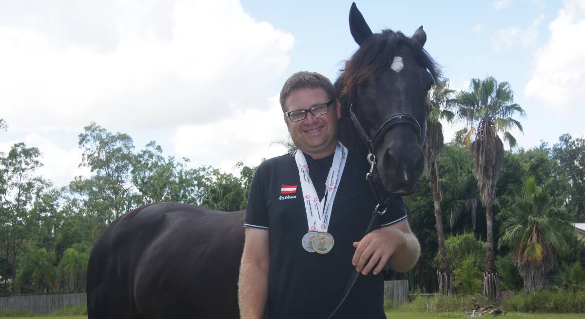 BEST FRIENDS: Australian Special Olympics Team Queensland participant Nathan Harvey with his black stallion Dom. Photo: Jacob Wilson.