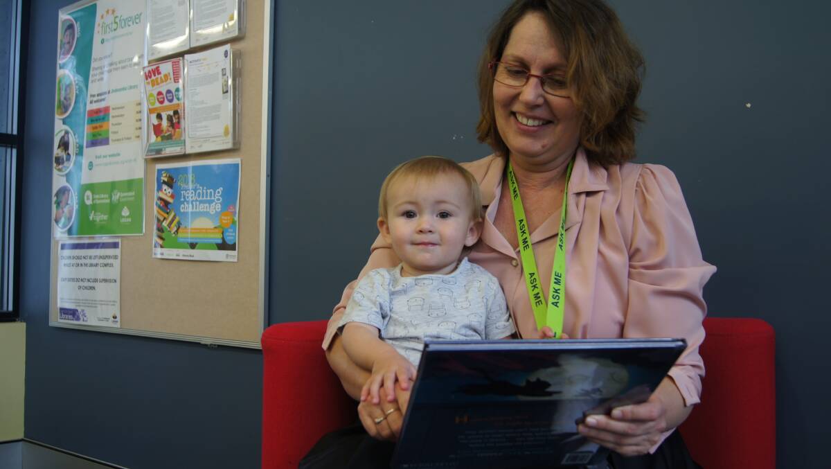 READING: Jimboomba library children services employee Pru Hird reads a book to young Greenbank child Darcie Catchpole. Photo: Jacob Wilson