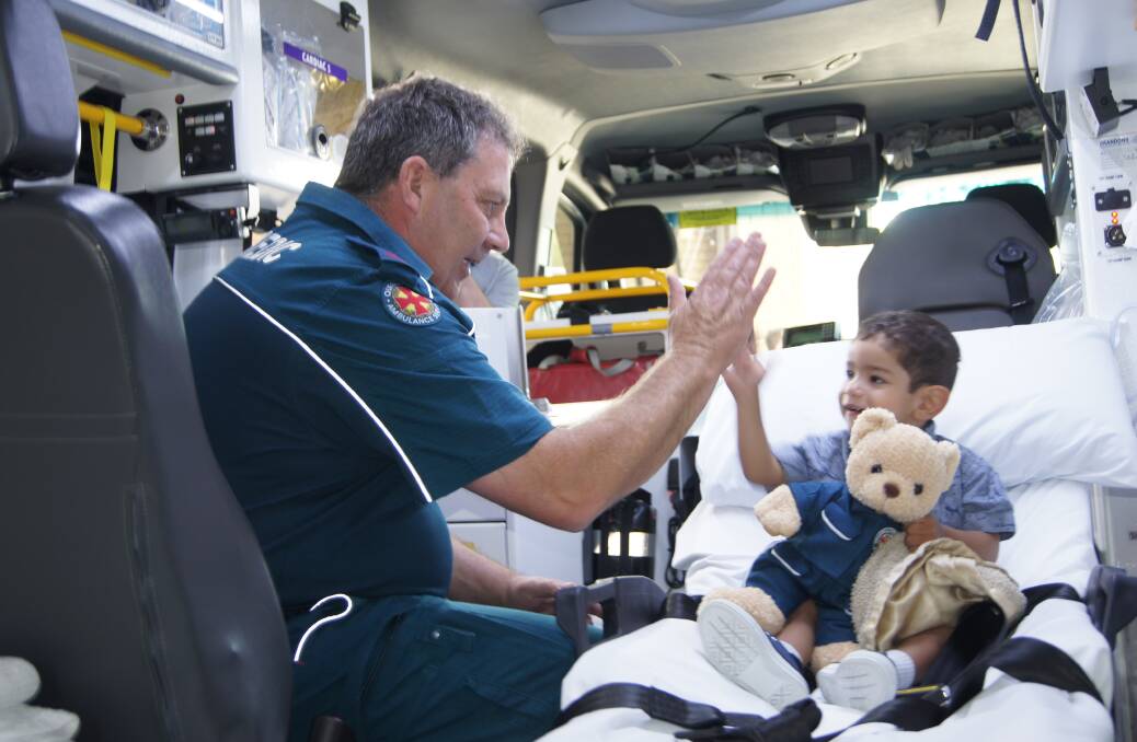 HIGH FIVE:  Advanced care paramedic Shane Mattingley with two-year-old boy Sebastian. Photo: Jacob Wilson