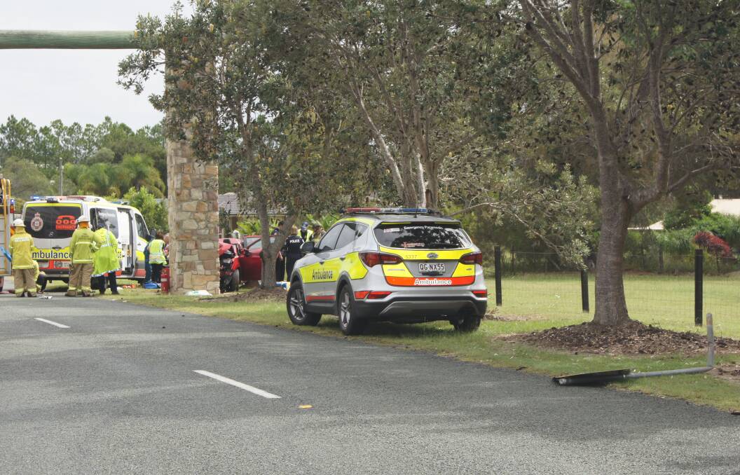 CRASH: Emergency Services worked to free a man from a red car at New Beith this morning. photo: Jacob Wilson