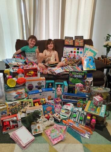Austin and Elizabeth Amour with the gifts they will donate to the Smith Family and Queensland Children's Hospital. Photo: Supplied