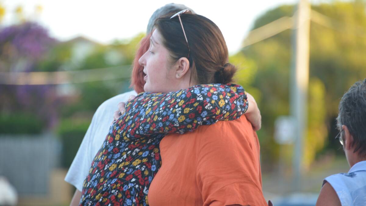 COMFORT: Danielle Leadbetter is comforted at the candlelight vigil.