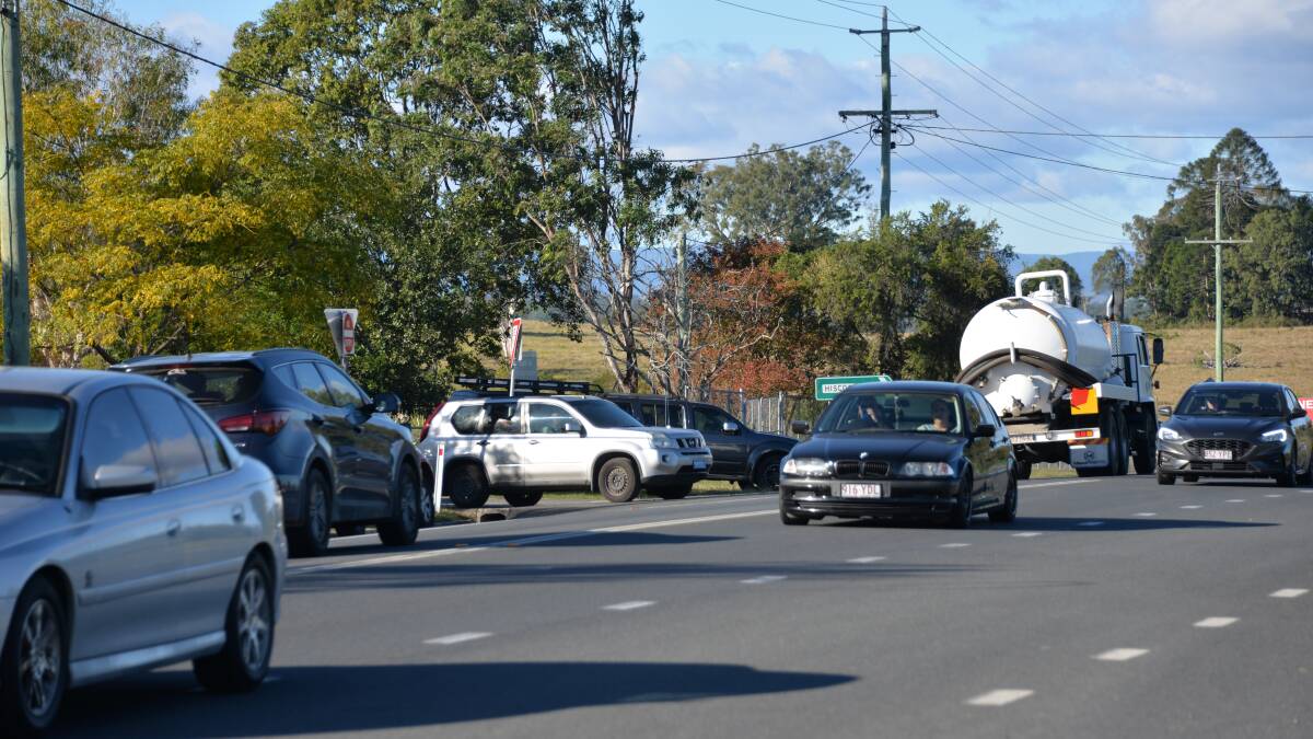 WOODHILL: Parents try to leave the state school parking area and enter the traffic flow as cars and trucks use the Mount Lindesay Highway. Photo: Brian Williams