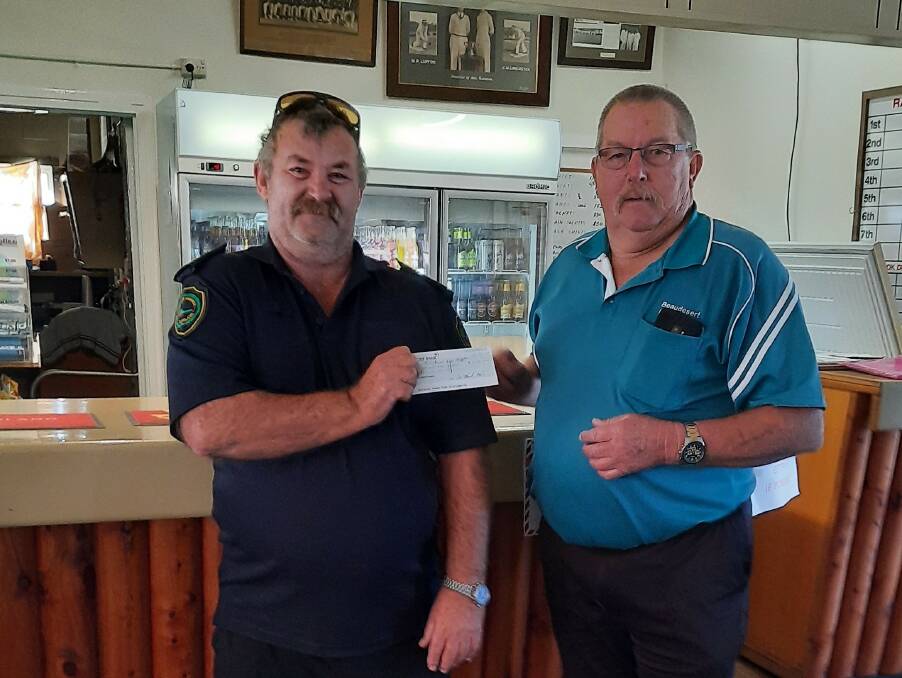 FOR FIRIES: Terry Watkins receives a donation from Mick Richardson at Beaudesert Bowls Club. Photo: Supplied