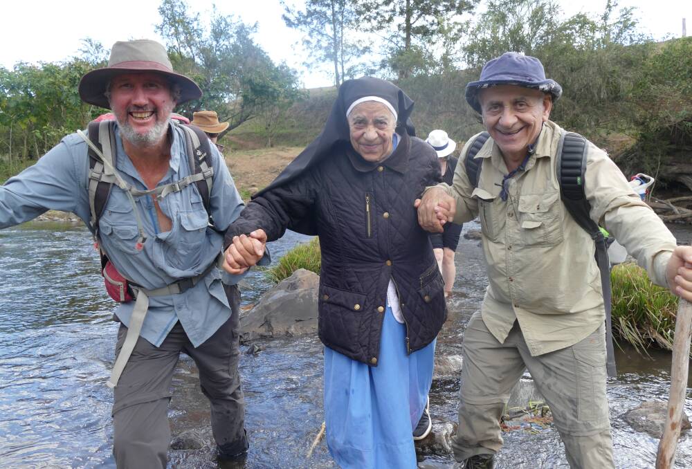 SHEPHERDS WALK: Fidaa Petrus, aged 80, being helped across the river by landowner Michael Undry and her brother Khaleel Petrus. Photos: Supplied