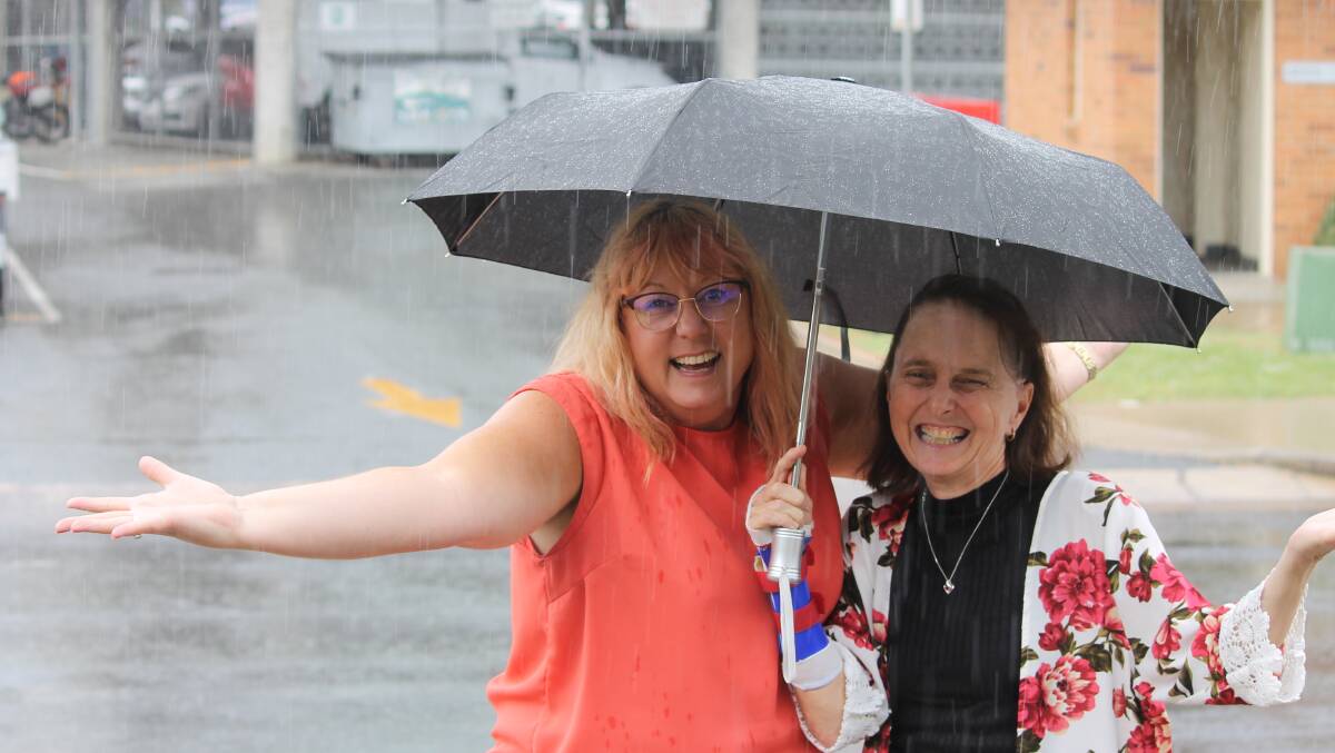  RAIN: Donna Collier and Shelly Bradley share an umbrella at Beaudesert earlier this year. Photo: Larraine Sathicq