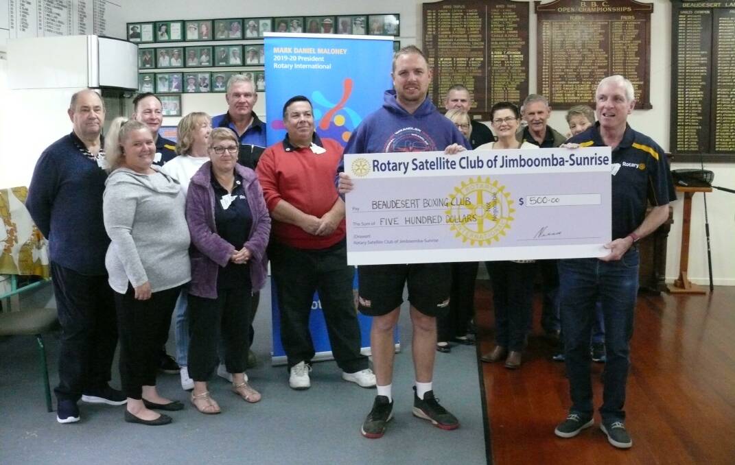 GIFT: Beaudesert Boxing Club founder Justin O'Leary receives a cheque from the Jimboomba Rotary satellite Sunrise Club. Photo: Supplied