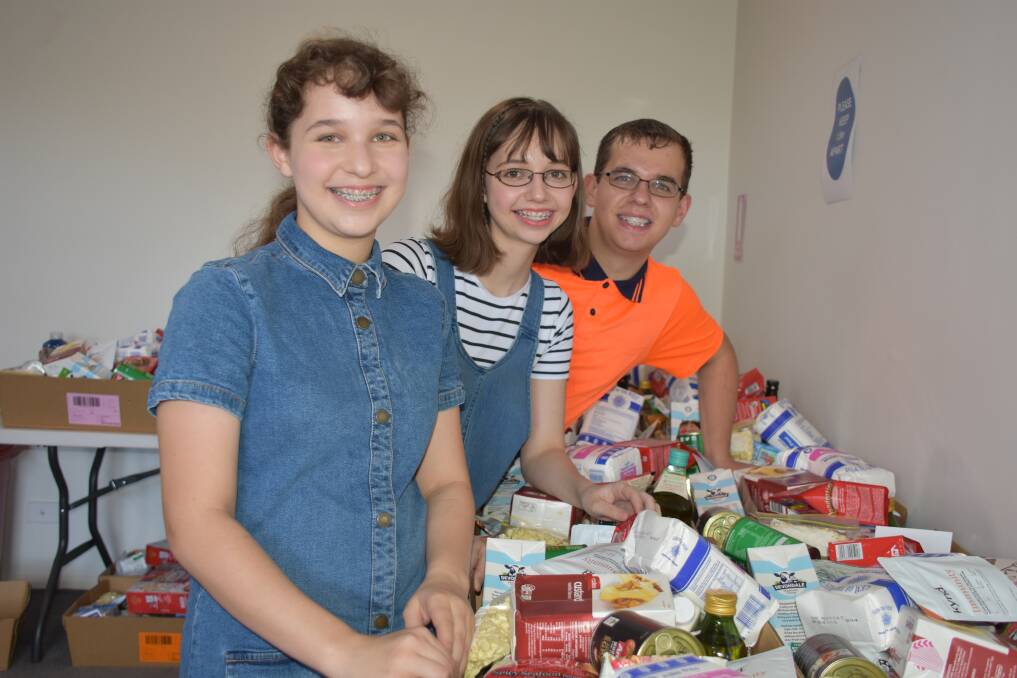 FAMILY AFFAIR: Jonathan Cinzio, Kiraleigh Cinzio and Kassi Cinzio help out their parents at Flagstone Food Bank.