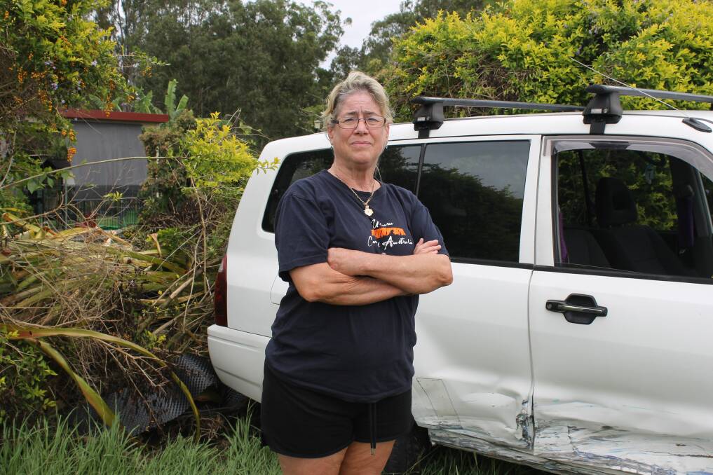 DAMAGE: Janelle O'Brien stands next to the car that smashed into their fence after a crash on February 15. Photo: Cheryl Goodenough