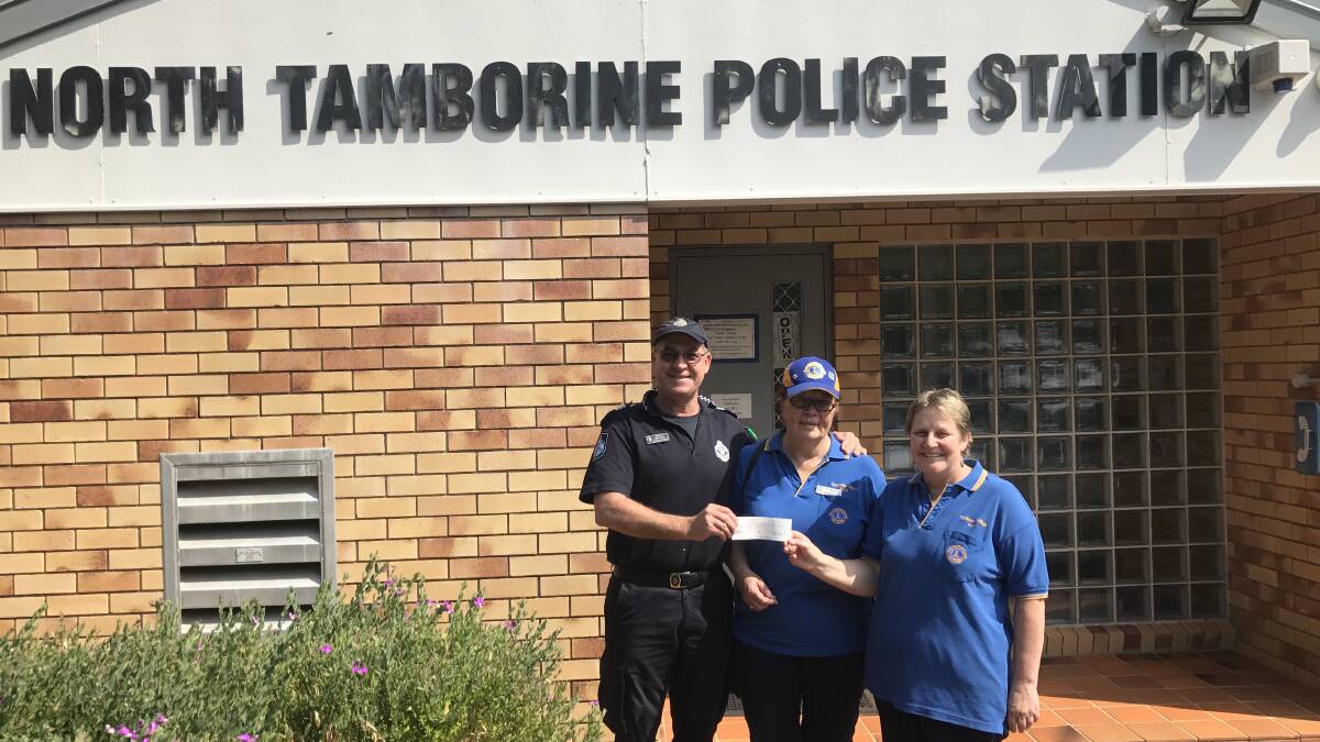 Sergeant Mick Jones receiving a cheque from Tamborine Lions Association members Carol Hines and Kath Murrie-Jones to support the Defensive Driving Programme.
