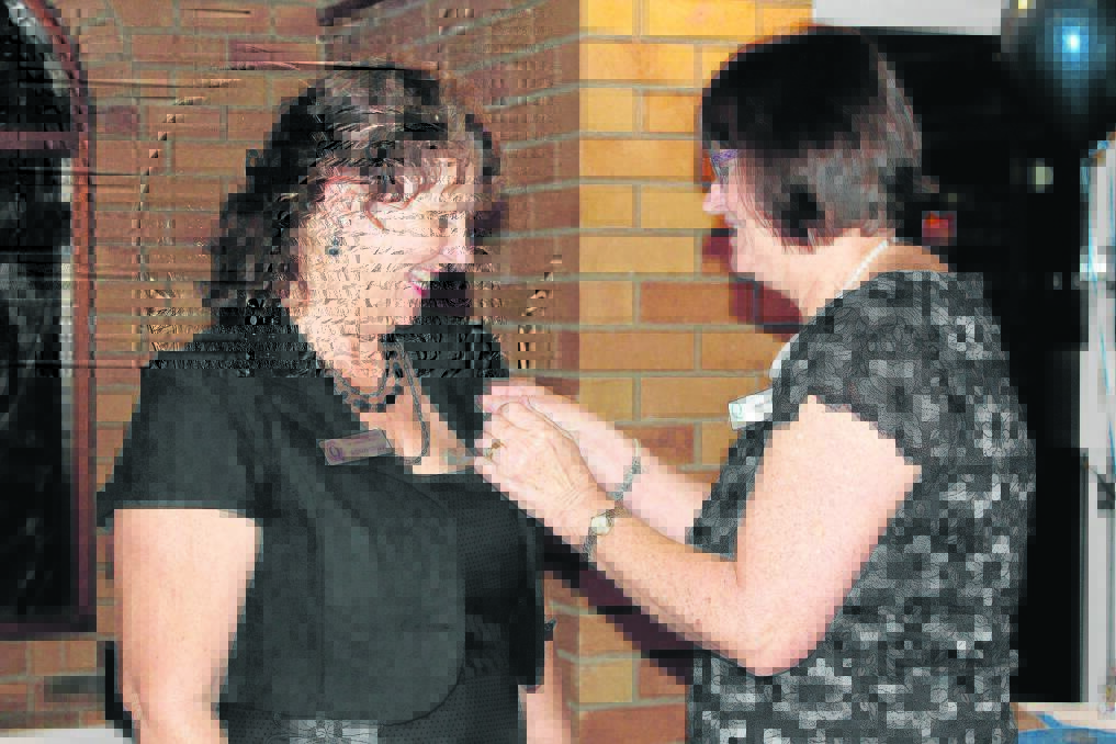 District governor Sandy Smith presents Wendy Fryer with her past president's pin.