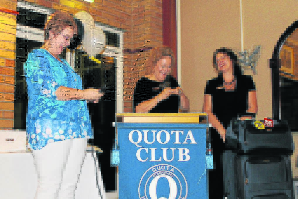 Shelly Wheeler and Romaine Farrer present gifts to outgoing president Wendy Fryer.