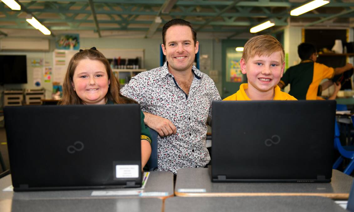 Overhaul: Jon Raven accesses the internet with Marsden State School students Marie Ash, of Waterford West, and Jess Obersteller, of South Maclean, as council prepares to study the ailing network in Logan.
