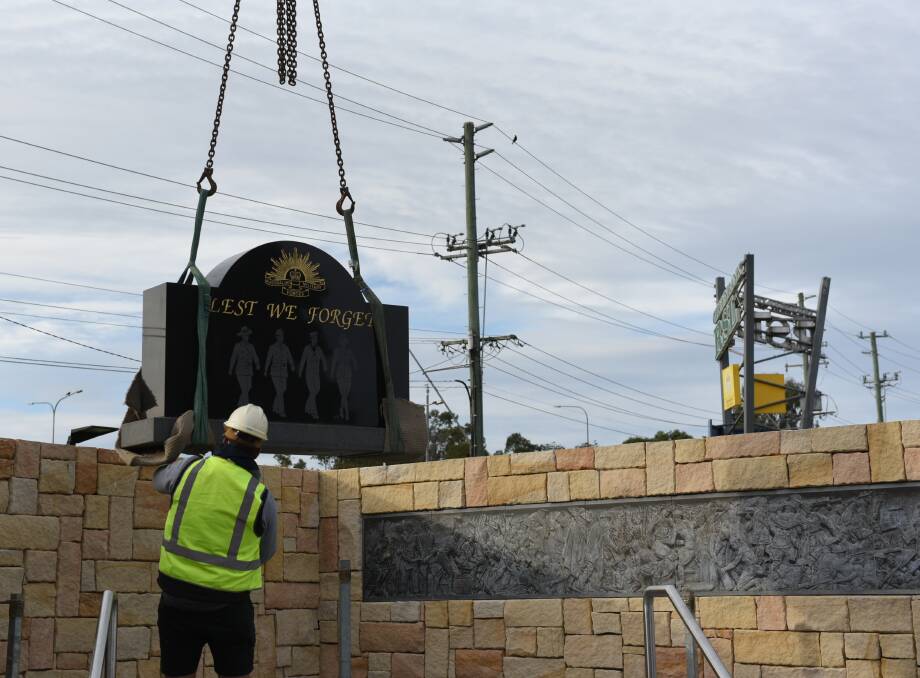 DROP IN: The Lest We Forget headstone was craned back into place at Greenbank RSL. Photos: Matt McLennan