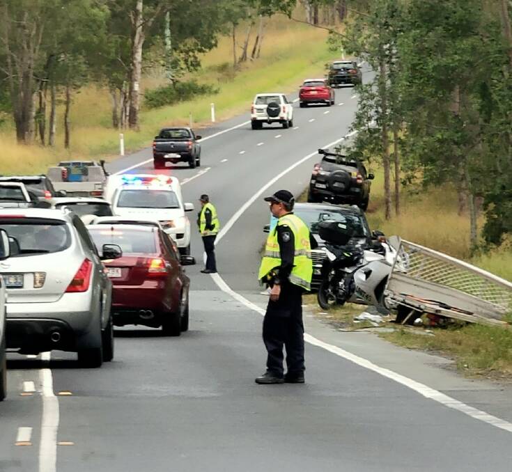 Smash: A policeman at the scene of an accident on the Mount Lindesay Highway. Photos: Louisa Angel.