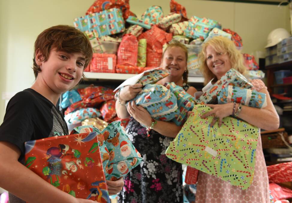 SPECIAL CHRISTMAS: Ryder Sullivan, Sally Brooks and Andy Mabey with some of the presents donated by Jimboomba locals for the toy drive. Photo: Matt McLennan