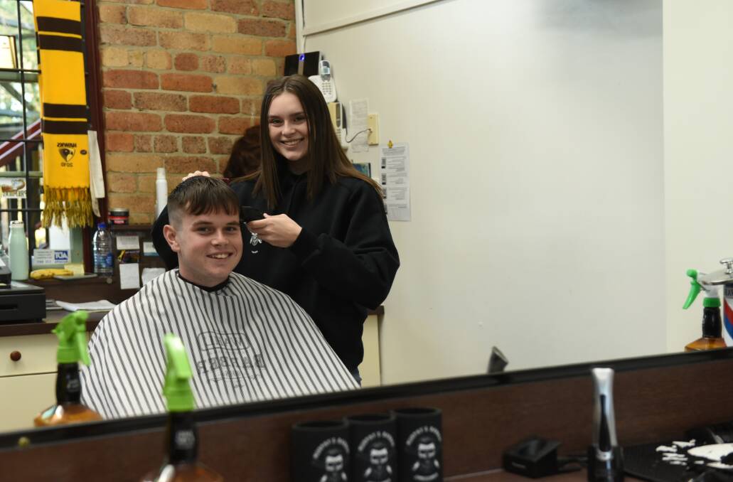 STAR APPRENTICE: Bree Connell gives brother Jake a haircut at Murphy's Barber Shop in Jimboomba.