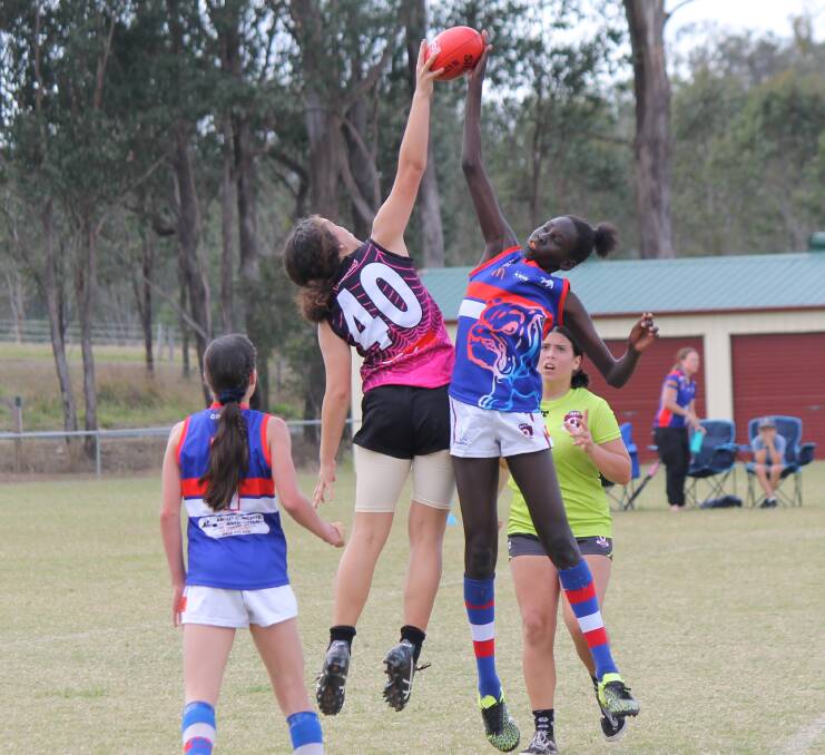 Leap: Elizabeth Tereroa, left competes for the ball in the match against the Ormeau Bulldogs in the under 13s. Photo: Alex Hodges