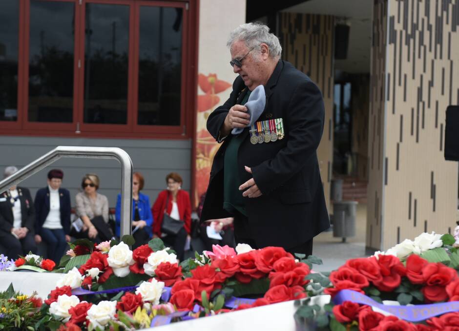 Respects: Tony Lourenson lays a wreath at today's Vietnam Veterans Day service at Greenbank. Photos: Matt McLennan