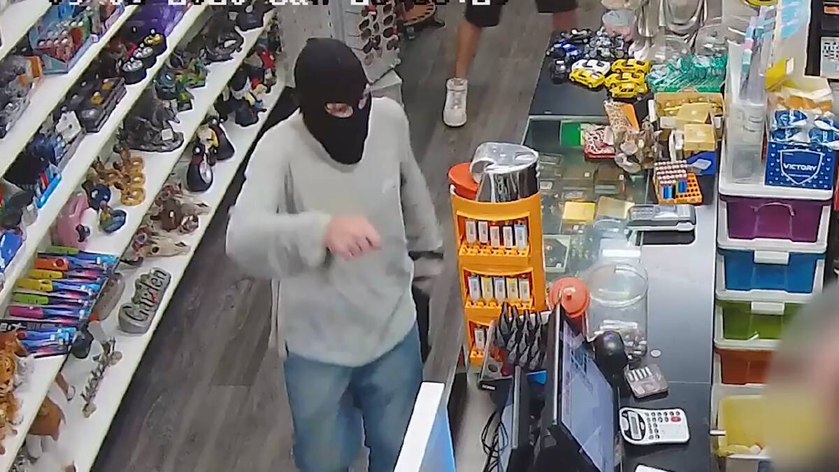 A still from the CCTV footage at a Crestmead tobacco store shows the offender brandishing a sharp object.
