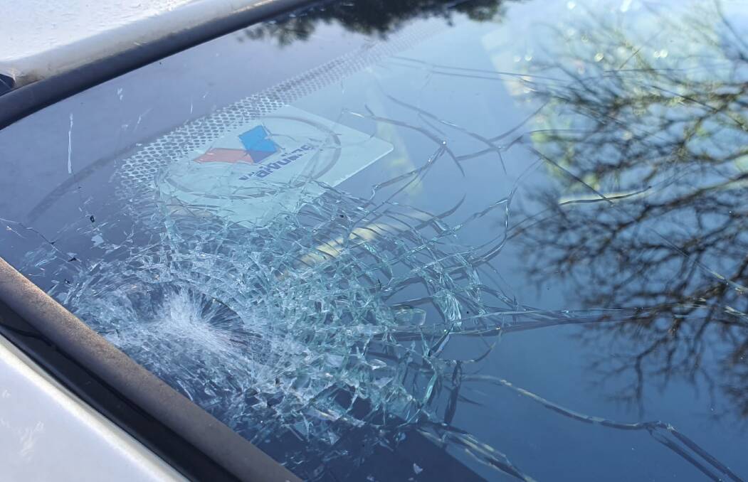 Damage: A Flagstone woman sat helplessly as her car was smashed by hail on Saturday as storms swept across the region.